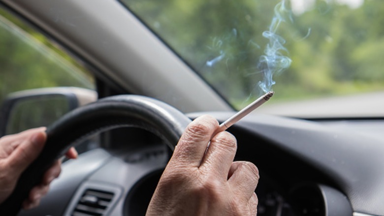 A person smoking a cigarette in a vehicle