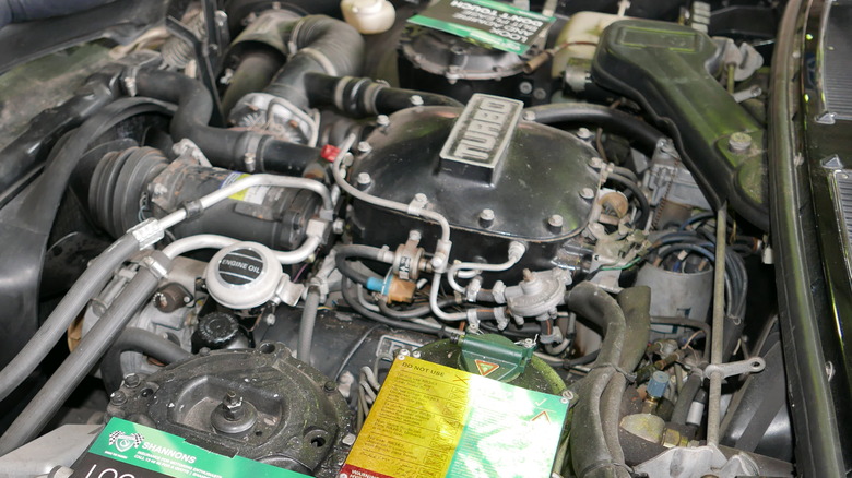 A 1985 Bentley Mulsanne Turbo sedan with the hood open and the V8 engine visible.