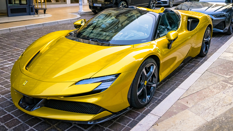 A yellow Ferrari SF90 Spider parked on the street.