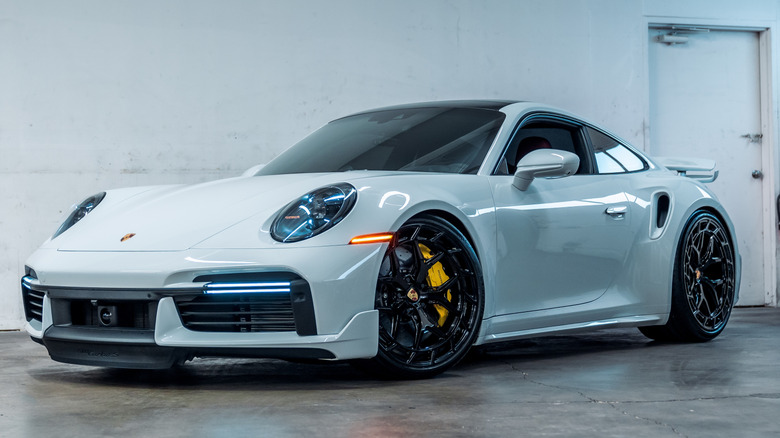 A white Porsche 911 Turbo S parked inside.