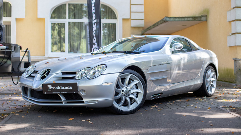 A silver Mercedes McLaren SLR parked on a city street.