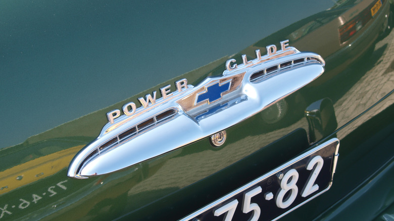A closeup of the Chevrolet bow-tie logo and Power Glide lettering on the rear of a green 1951 Chevrolet Bel Air with a Powerglide 2-speed automatic transmission