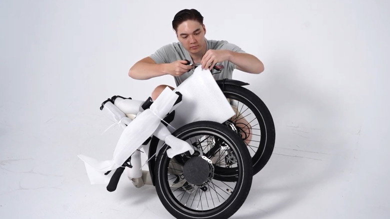 Man unboxing folded up Himiway B3 folding e-bike
