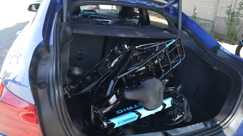 Folded up Lectric XP 3.0 in the open trunk of a car