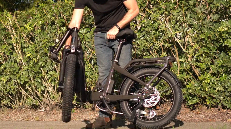 Man folding up Ride1Up Portola folding e-bike