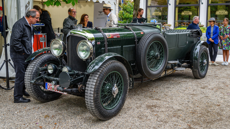 A forest green 1930s Bentley 8-liter cabriolet parked on display.