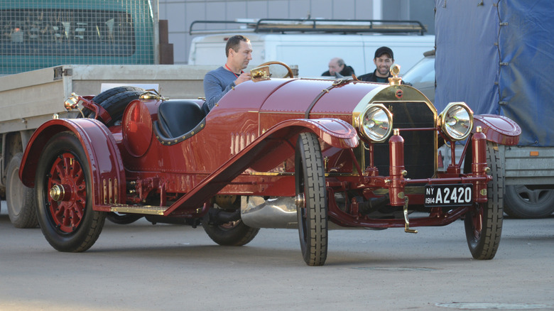 A maroon Locomobile Model 48 being driven on a road.