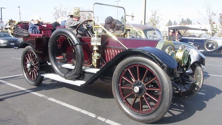 A maroon 1910s Oldsmobile Limited car parked.