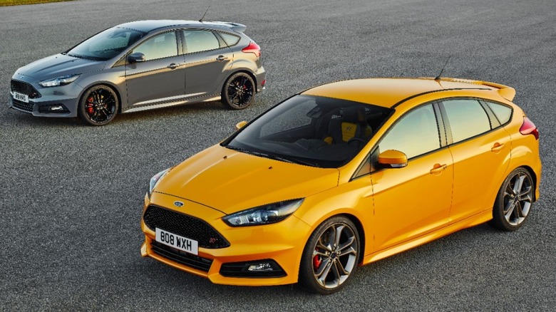Two 2015 Focus ST models, one gray and the other yellow, parked on a track