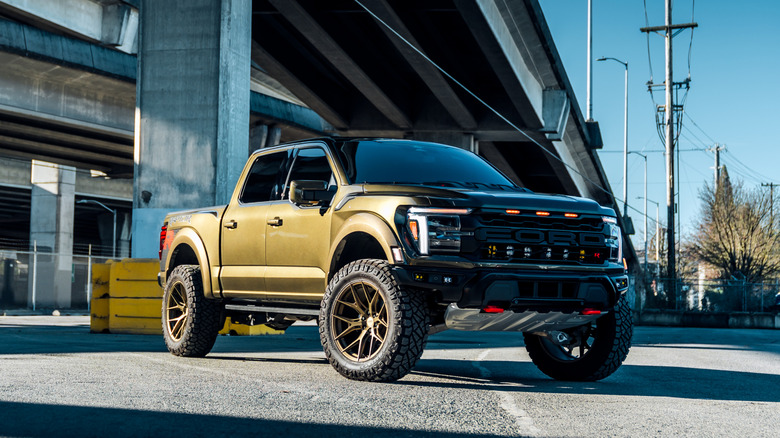 A metallic green 2025 Ford Raptor R parked under a bridge.
