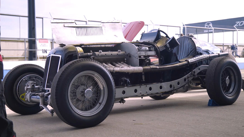 A 1935 ERA race car parked with its engine displayed