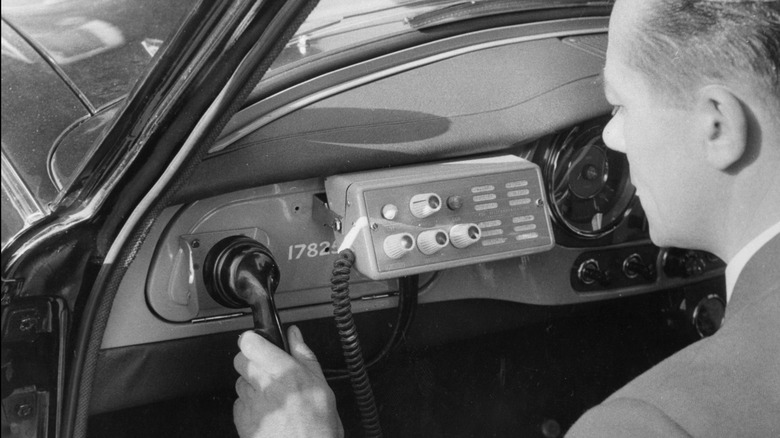 Man using an early car radio telephone.