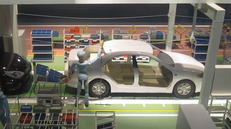 An animatronic display of a Toyota worker pulling the Andon cord to alert a boss to a problem on the assembly line.