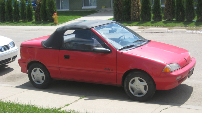 1989–1991 Pontiac Firefly convertible parked on one side of street with a building in the background