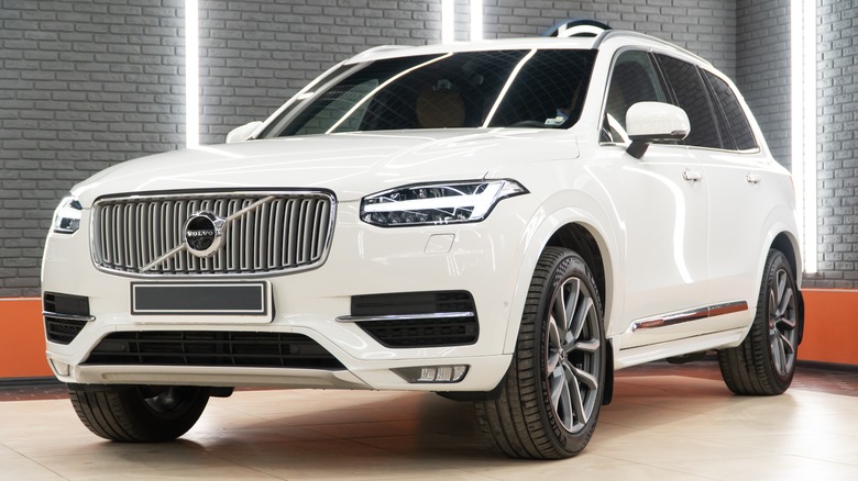 A white Volvo XC90 in a showroom.