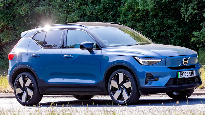 A blue Volvo XC40 against a background of trees.