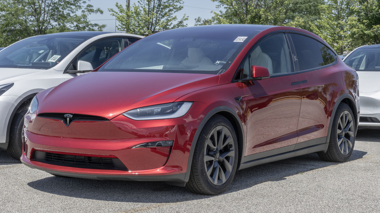 The front-left 3/4 of a red Model X in a parking lot