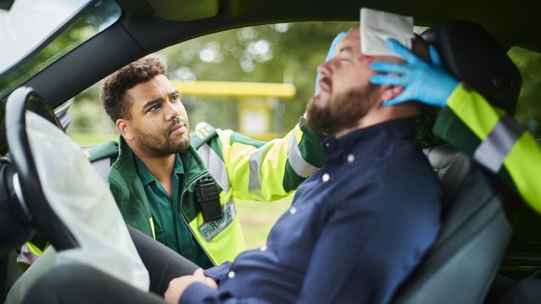 Paramedics aiding man injured in car wreck