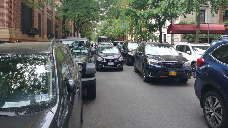 A traffic jam on residential city street with double-parked car