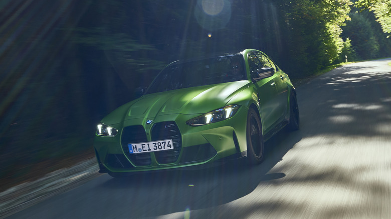 A green BMW M3 Competition on a road.
