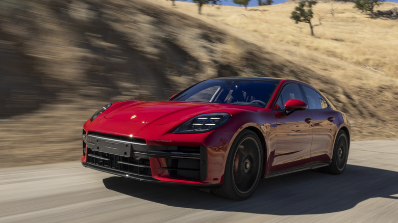 A red 2026 Porsche Panamera GTS on a road.