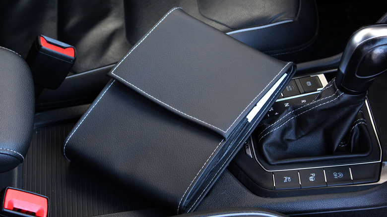 A car's document holder, with service book and manual inside
