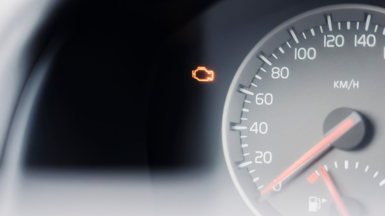 A car's check-engine light illuminated on the dash near the speedometer