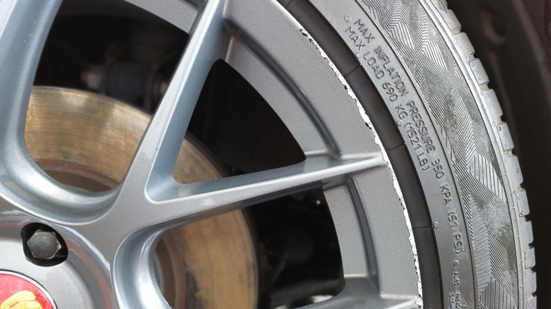 Tire rim that is damaged from having scraped the curb