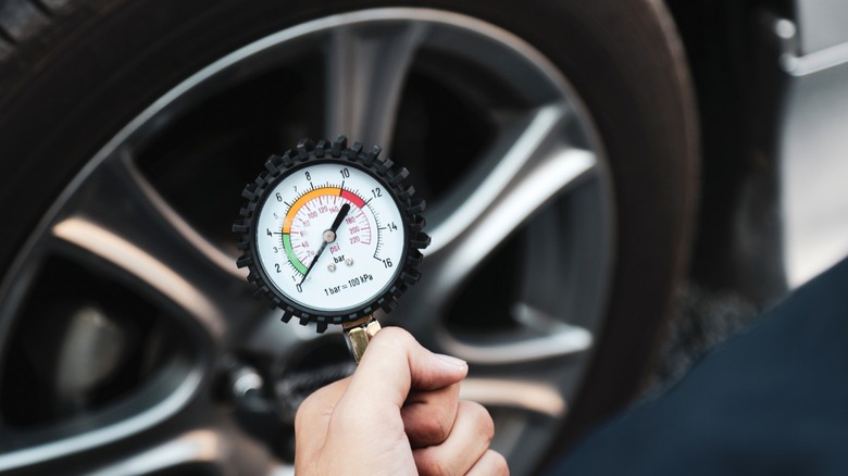 Tire gauge being held in front of tire