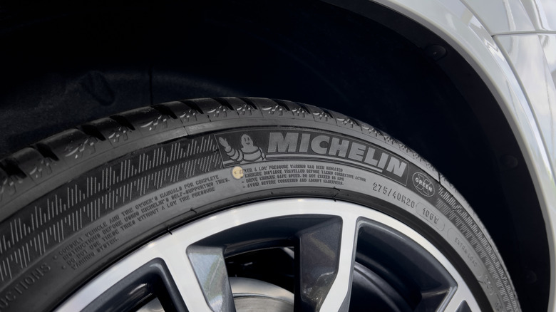 A close-up of a Michelin tire mounted on a rim on a car.