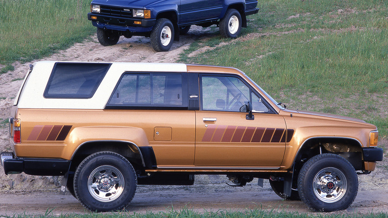 Gold and blue 1984 Toyota 4Runners on a hill.