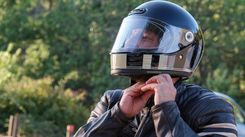 Motorcyclist puts on helmet