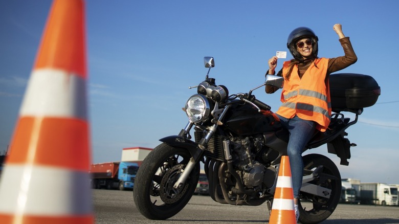Motorcyclist holding license after completing safety training course