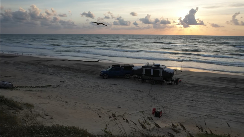 A truck with camper trailer set up on Padre Island National Sea Shore