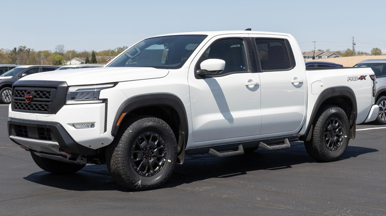 A parked, white 2023 Nissan Frontier pickup truck.