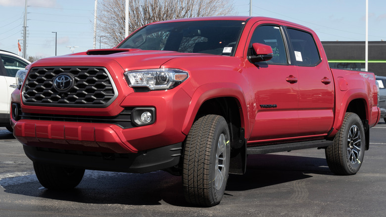 A red 2023 Toyota Tacoma parked outside a dealership.