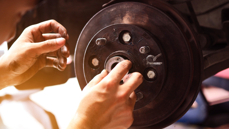 A car wheel bearing being examined by a person