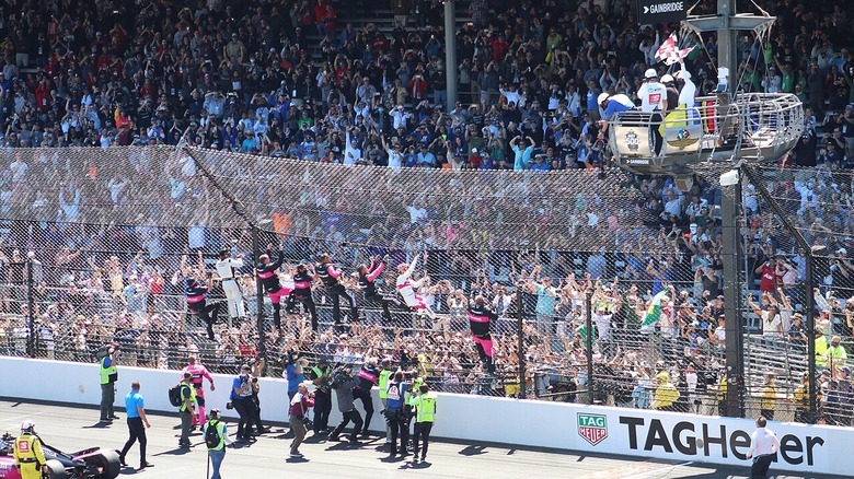 Hélio "Spiderman" Castroneves climbing the fence at Indy