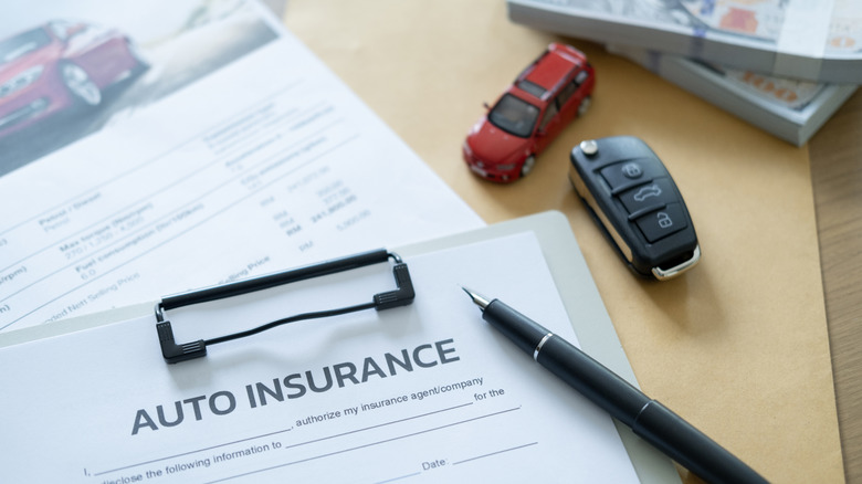 Auto insurance form on a table with a pen