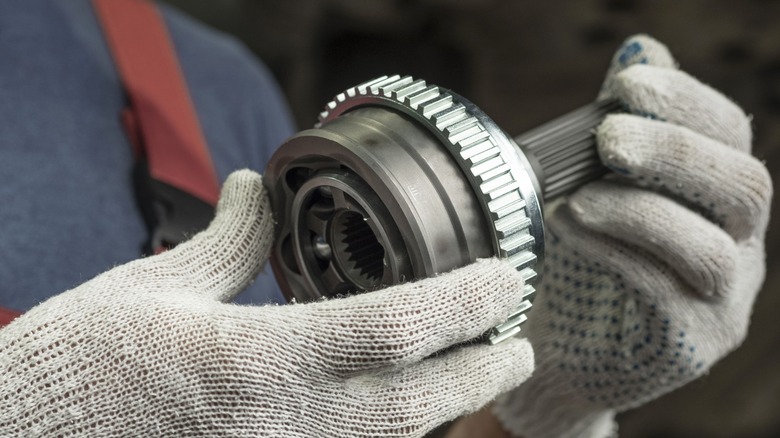 Mechanic holding CV axle.