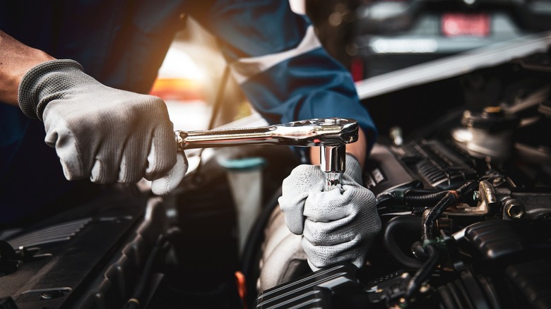 Mechanic performing repairs connected car.