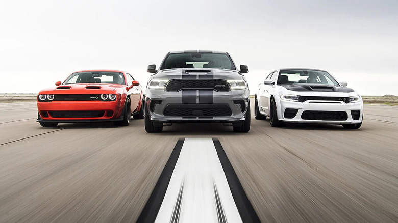 A trio of aggressive sports vehicles driver forward on a runway.