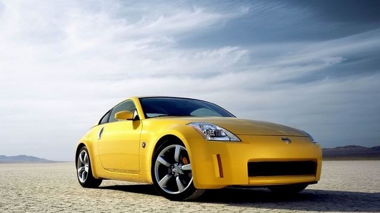 A yellow 2005 Nissan 350Z 35th Anniversary Edition parked on a cracked desert dry lake bed.