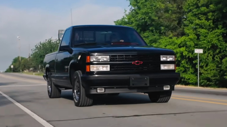 A black pickup Chevrolet 454 SS  is seen from the front quarter as it drives down the road.