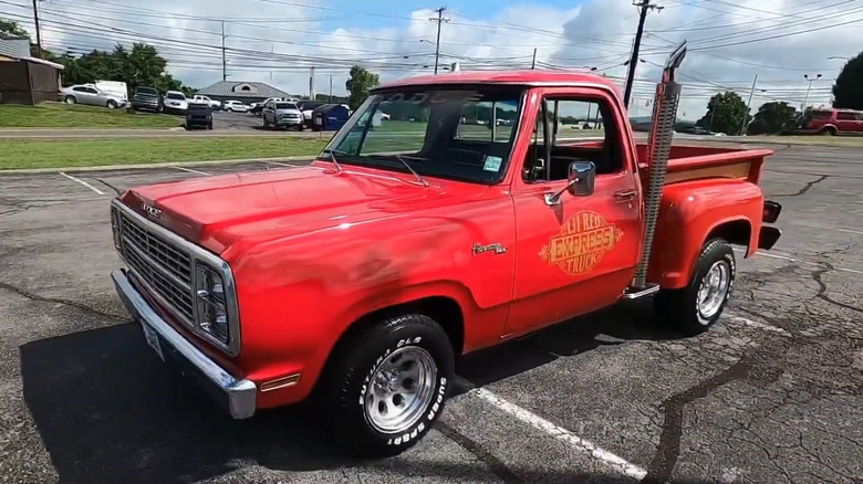 A red pickup Dodge Li'l Red Express truck faces to the left with vertical stacks rising up from behind the cab.