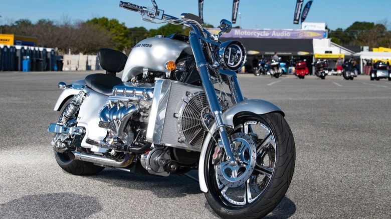 A silver Boss Hoss 496 parked in a huge parking lot.