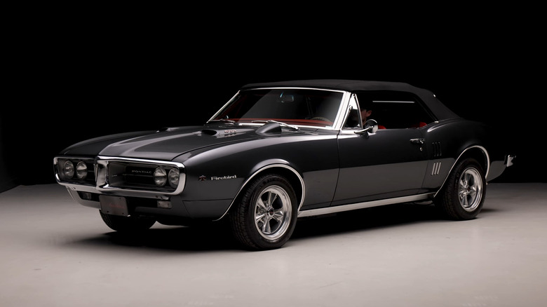 A charcoal gray 1968 Pontiac Firebird 400 convertible with a black soft top.