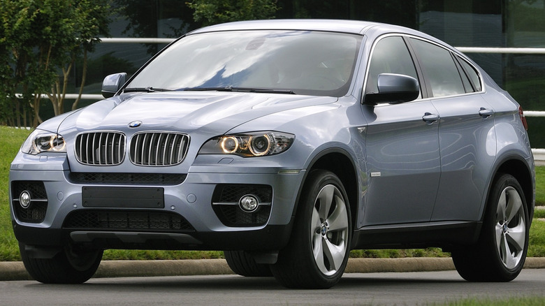 A 2010 BMW X6 ActiveHybrid driving slowly on a road.