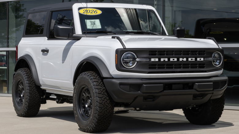 A white Ford Bronco Base two-door parked outside a dealership.