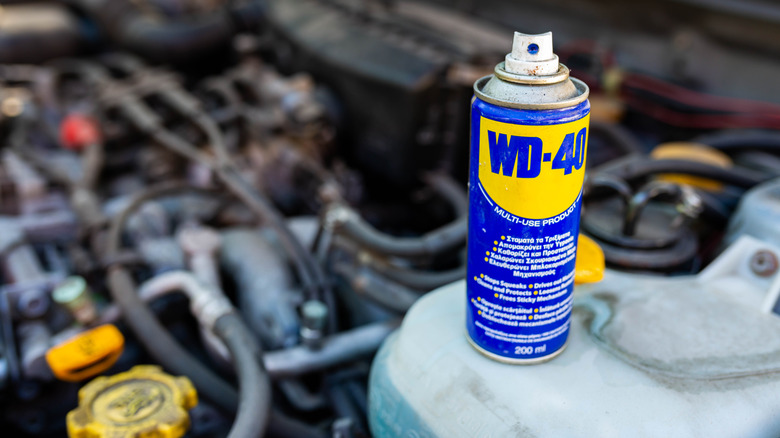 Can of WD-40 with engine bay behind it